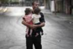 father-carrying-his-two-babies-gaza-july-2014